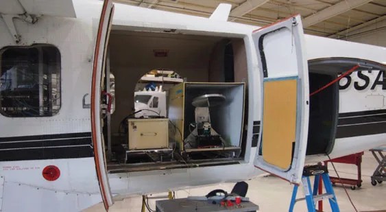 Photograph of science instrument on board a small airplane.