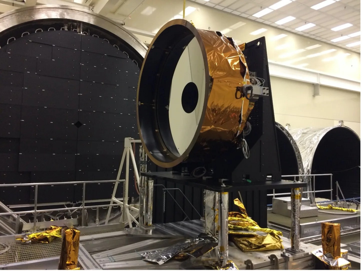 Photo of large mirror being assembled in a NASA facility.