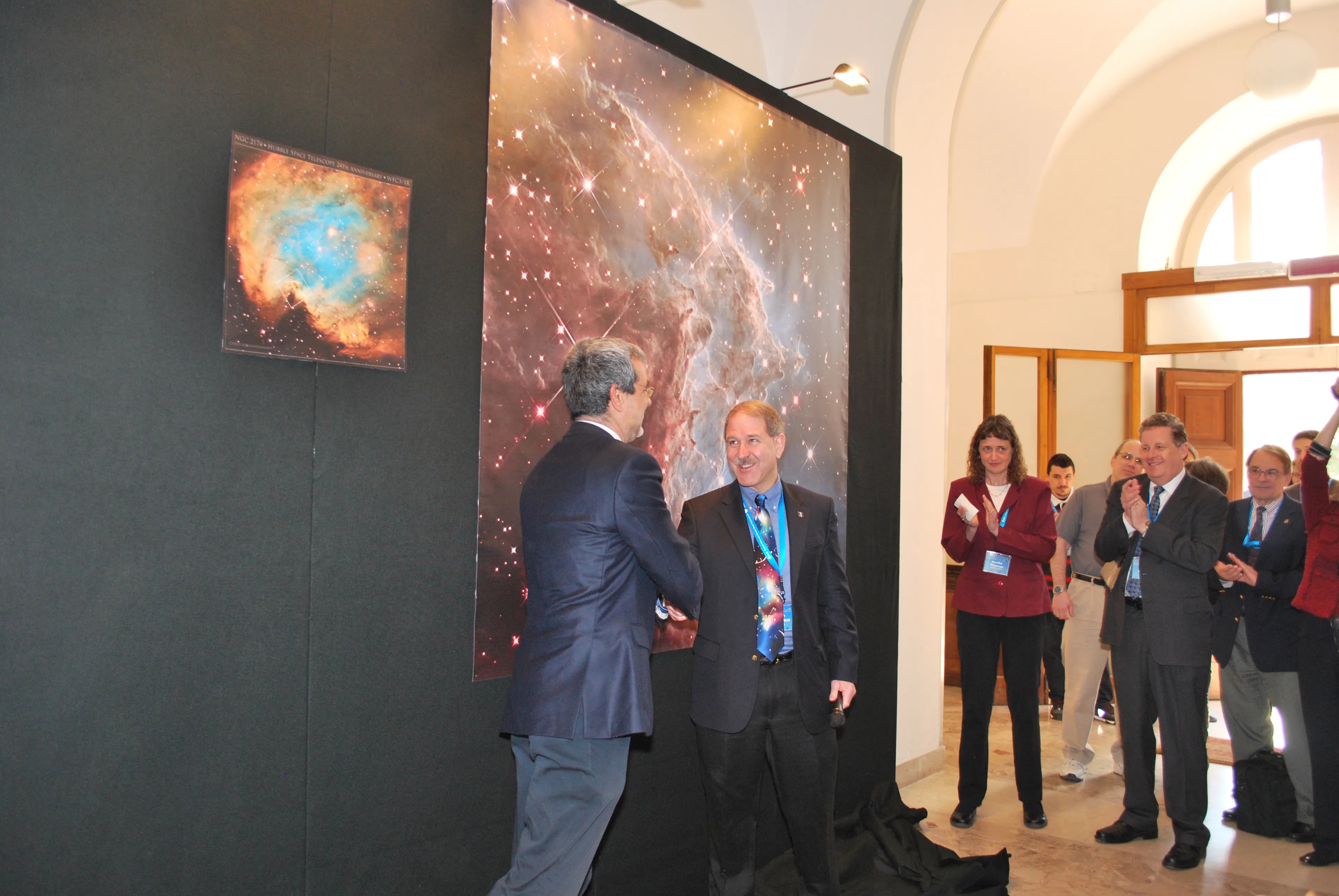 john grunsfeld, nasa's science mission directorate associate administrator, and fabio favata, head of esa’s science planning and community coordination office, shake hands after unveiling hubble’s 24th anniversary image last week in rome, italy.