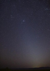 The night sky with a faint band of light that extends from the lower right to the upper left. A slight orange glow is visible along the horizon.