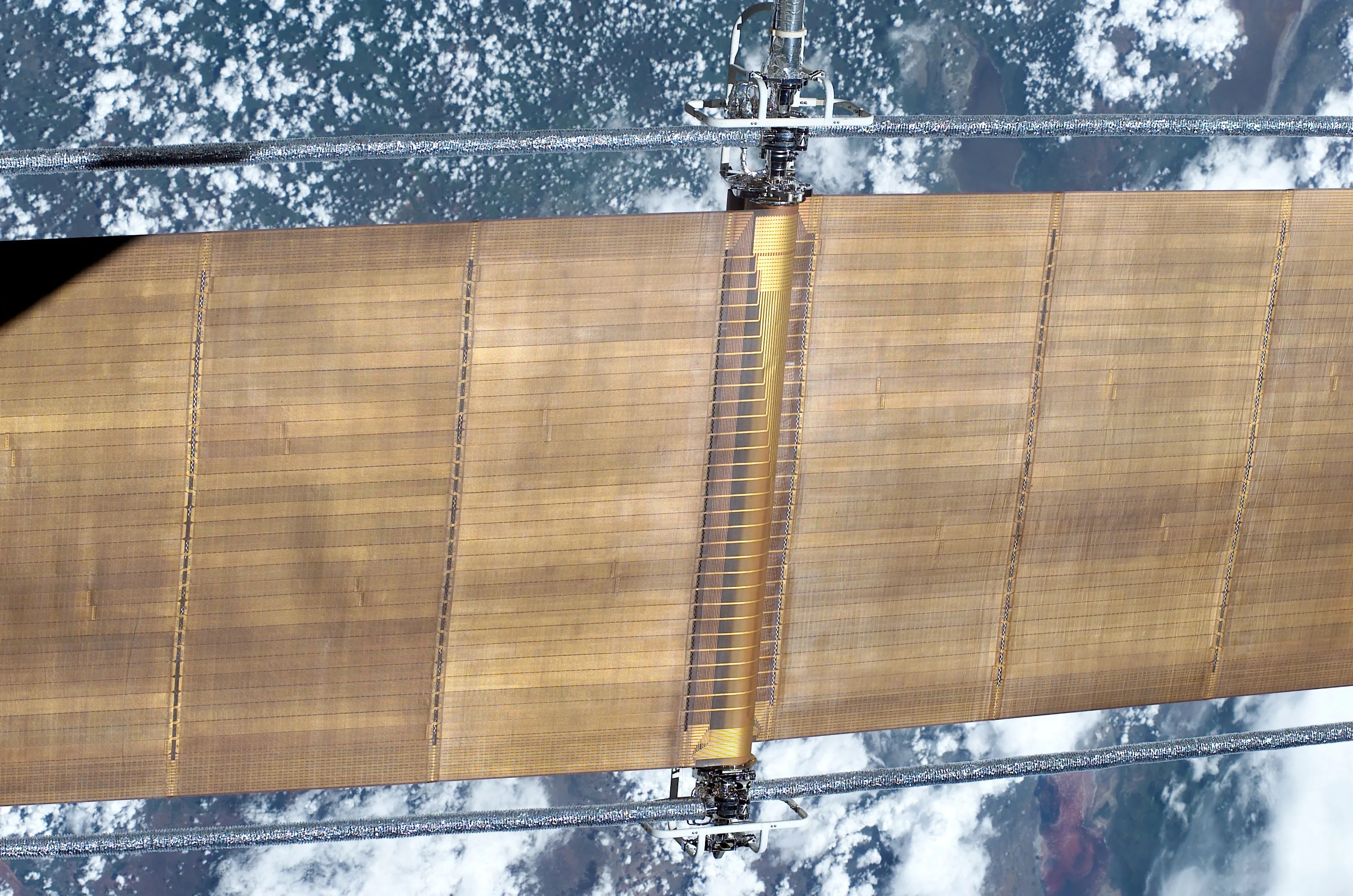 Gold solar array in foreground and Earth in the background.