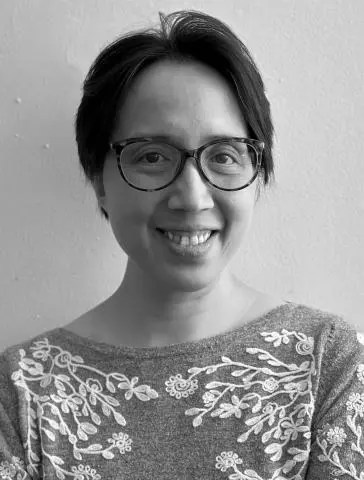 Black and white photo of a smiling woman with short dark hair and eye glasses