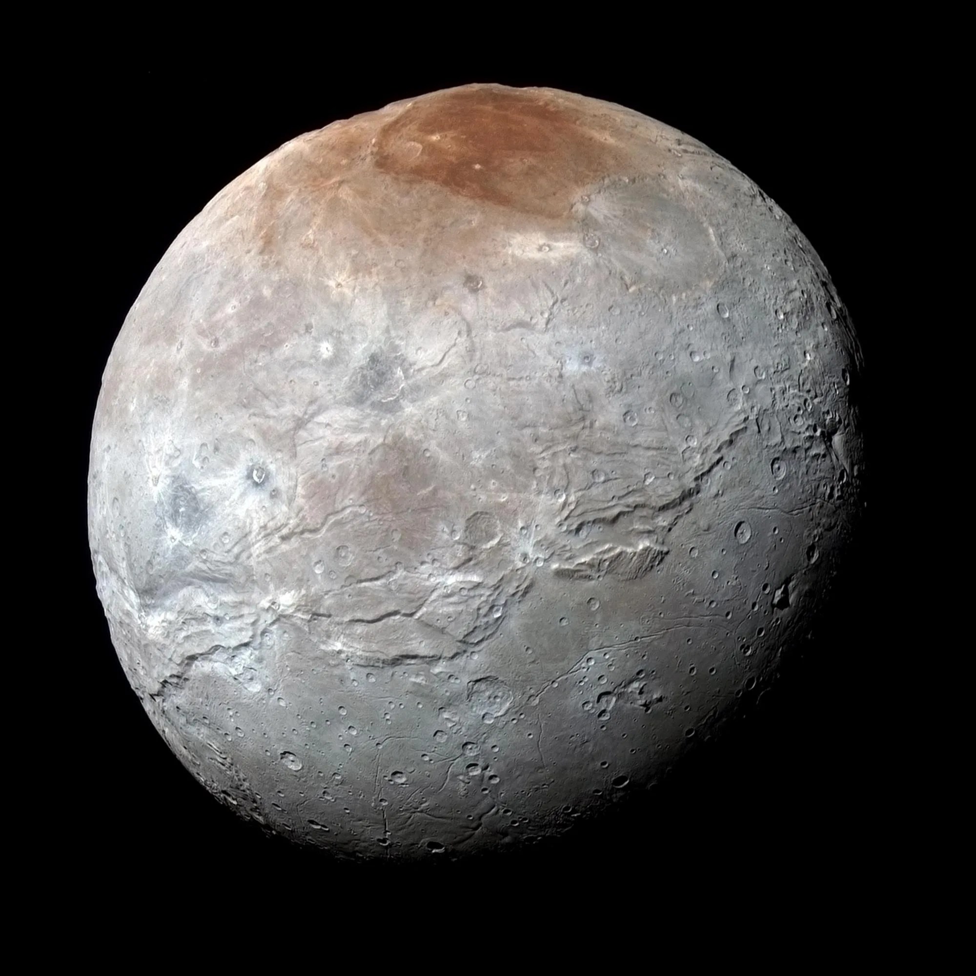 A full globe image of Pluto's moon, Charon. The moon is gray with a reddish spot at the top in this image.