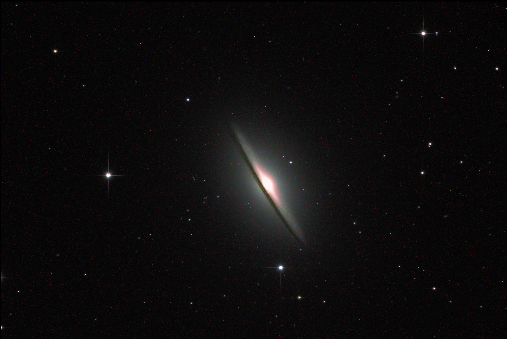 The Sombrero Galaxy looks like a diagonal, with a bright spot in the center with a hard line in front of it set against a black background with small and pinpoint white spots.