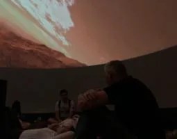 Dr. Michael Evans and college students in a planetarium