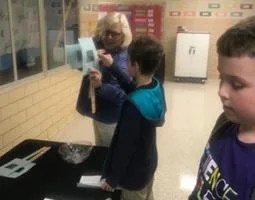 Betsy McAllister engages an elementary school student in a hands-on demonstration.