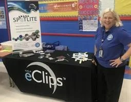 Betsy McAllister poses with an eClips/Spotlite display table.