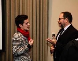 Dr. Jonathan Lunine converses with a man in a red scarf.