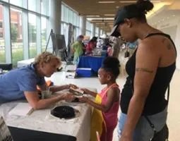 Dr. Sharon Bowers helps a young participant create moon maps with bubbles and paint at NASA’s Langley Youth Day
