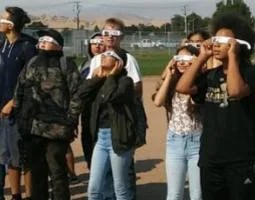 High school students wearing eclipse glasses