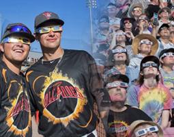 Salem Keizer Volcanoes fans and players wearing eclipse glasses