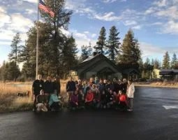 Workshop participants pose in front of a U.S. flag at Turnbull National Wildlife Refuge