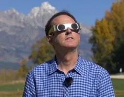A man wearing glasses designed for safely viewing the eclipse