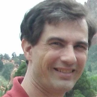 close up photo of a smiling man with brown hair