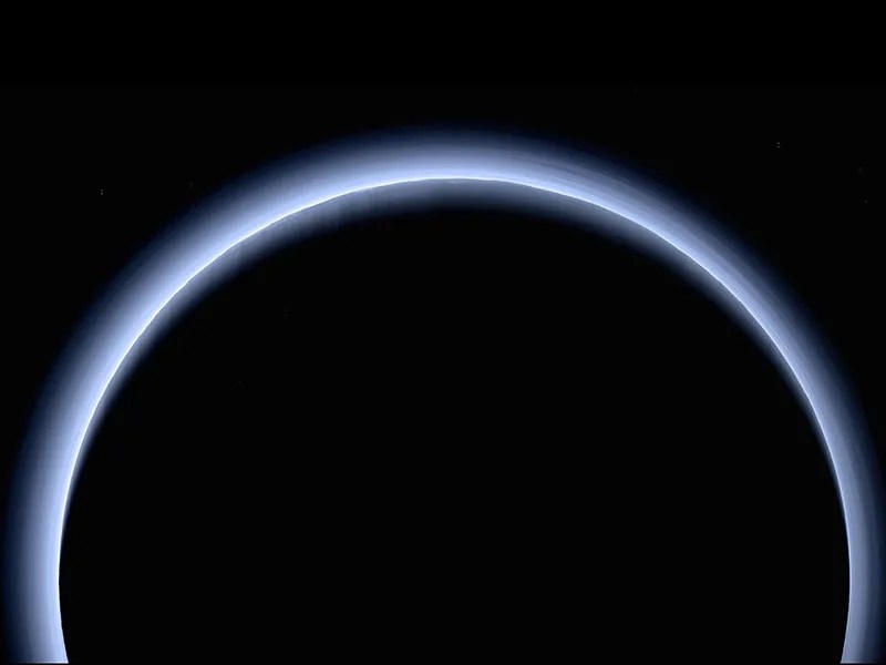 Blue haze encircling dark orb of Pluto.