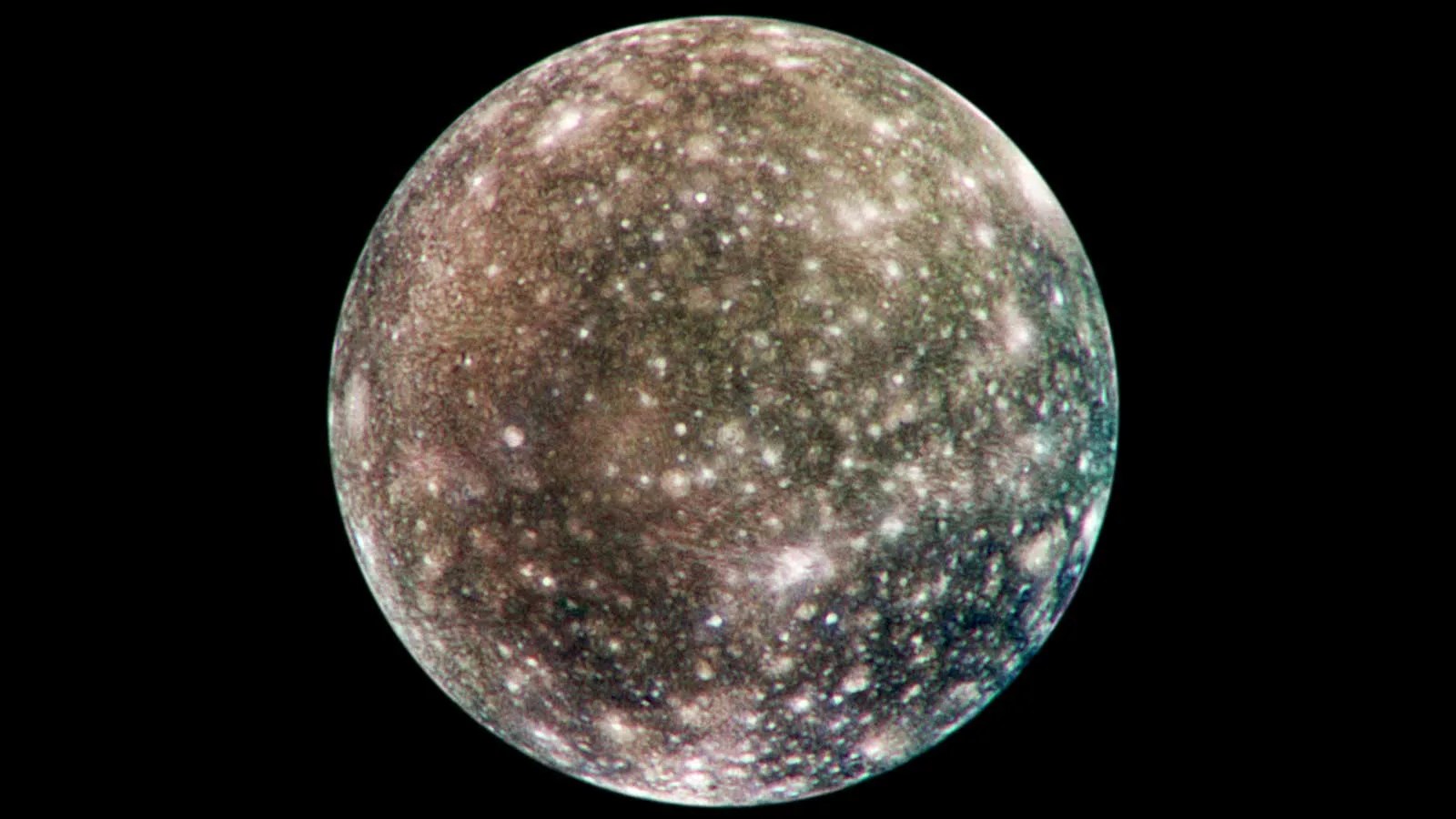 Jupiter's moon Callisto appears in space, pockmarked by many bright craters in its dark, brown surface.