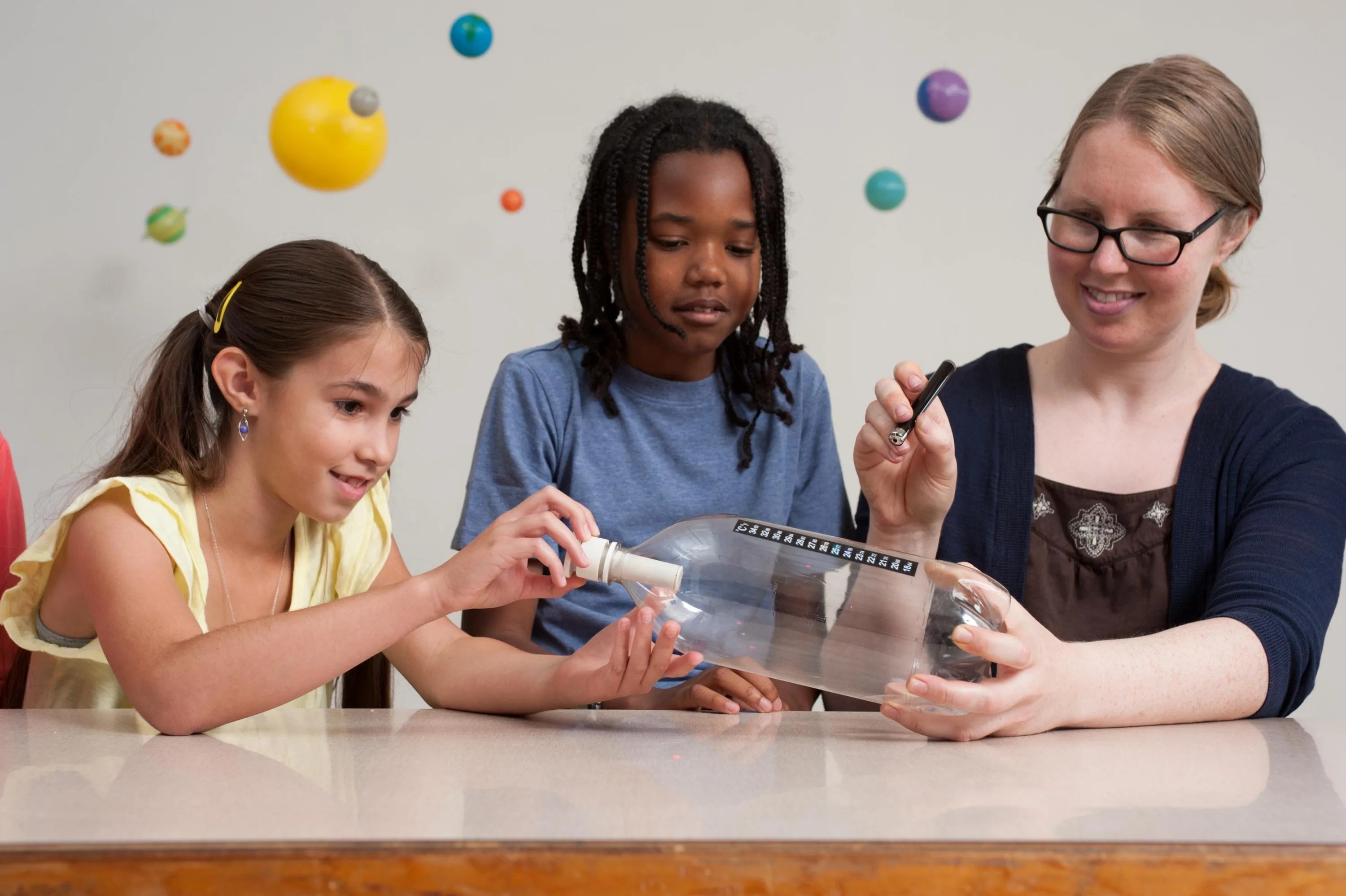 Photo of teacher and students doing a science experiment.