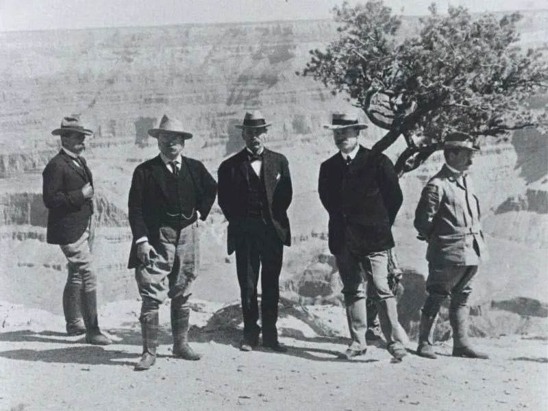 Five men, including President Theodore Roosevelt, pose in front of the Grand Canyon.