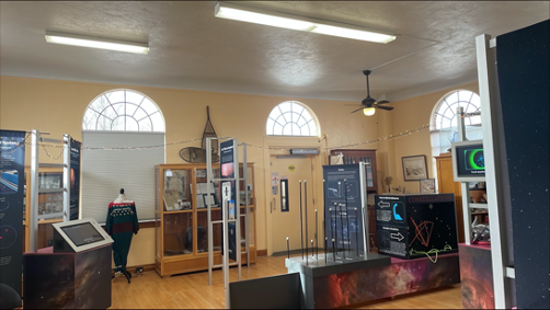 A museum exhibit space with multiple stations of the Discover Exoplanets exhibit. Each station has a display with informative text, images, and a hands-on activity.