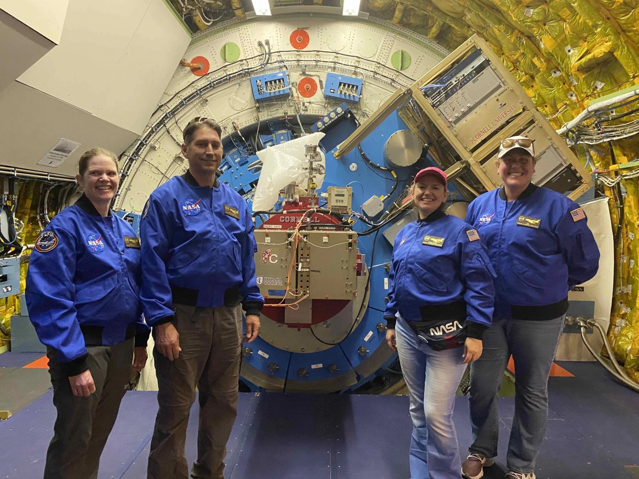 A team of AAA teachers in front of the FORCAST mid-infrared camera mounted on SOFIA’s telescope.