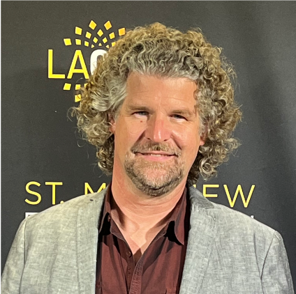 Portrait photo of a man with curly blonde hair