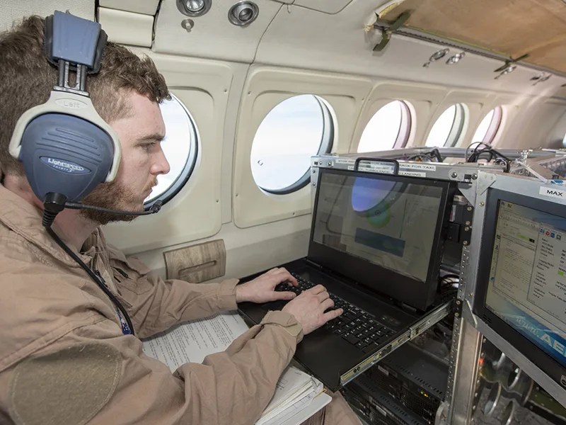 Man using computer on airplane