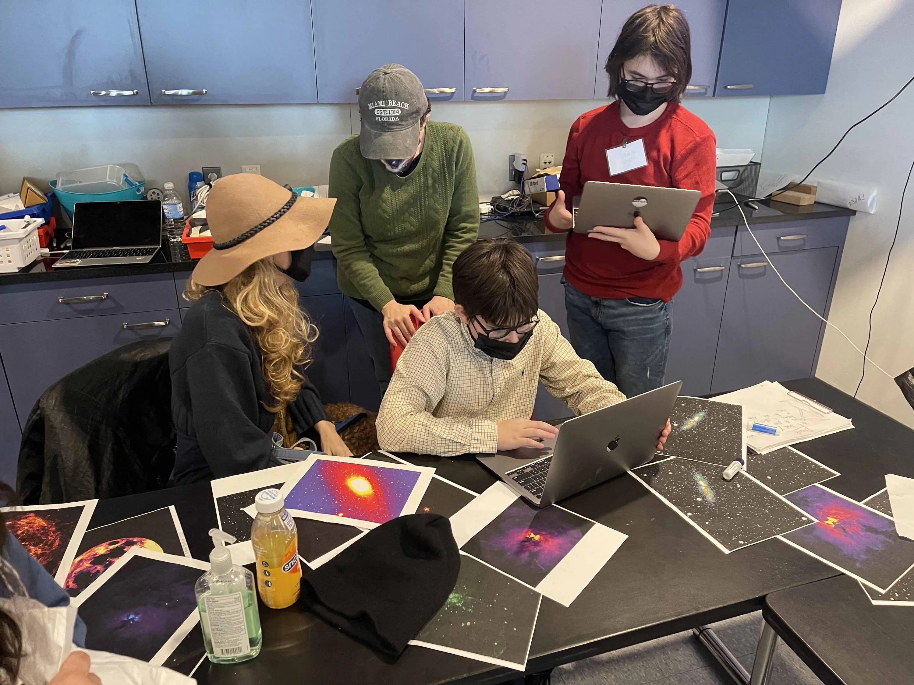 Docents at the New York Hall of Science work with a group of students who are learning about astronomical images in multiple wavelengths of light.