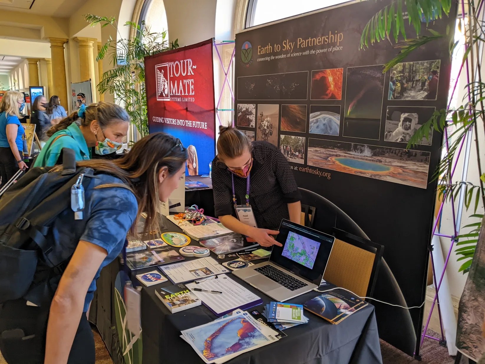 At the Earth to Sky booth, Hazel Galloway helps interpreters at the NAI conference understand how to use timelapse Landsat satellite imagery to tell stories of change at their sites.