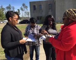 Four female teachers having a discussion next to a building