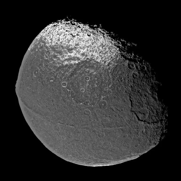 Cassini flew past Iapetus on New Year's Eve 2004, capturing the four visible light images that were put together to form this global view. The scene is dominated by a dark, heavily-cratered region, called Cassini Regio, that covers nearly an entire hemisphere of Iapetus.