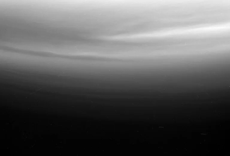 Multiple upper stratospheric haze layers are evident in this ultraviolet view from Cassini looking toward Titan's south pole. Original image released Feb. 23, 2005.