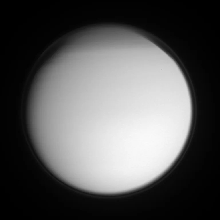 Titan's detached, high-altitude haze layer encircles its smoggy globe in this ultraviolet view, which also features the moon's north polar hood. The northern hemisphere is currently in its Winter season.
