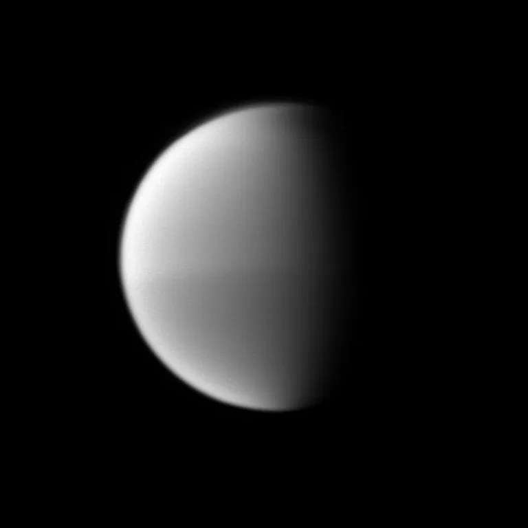 Titan's seasonal hemispheric dichotomy is chronicled in black and white, with the moon's northern half appearing slightly lighter than the dark southern half. North on Titan is up. Image taken Oct. 16, 2009.