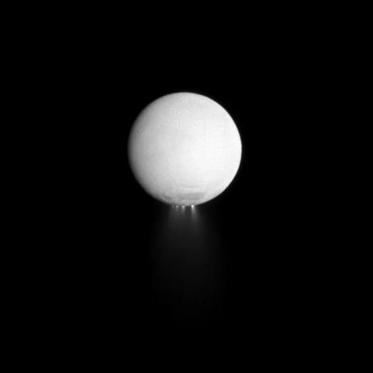 Jets of water ice particles, along with gases dominated by water vapor, spew out from the south polar region of Saturn's moon Enceladus in this dramatically illuminated image. Image taken Dec. 25, 2009.