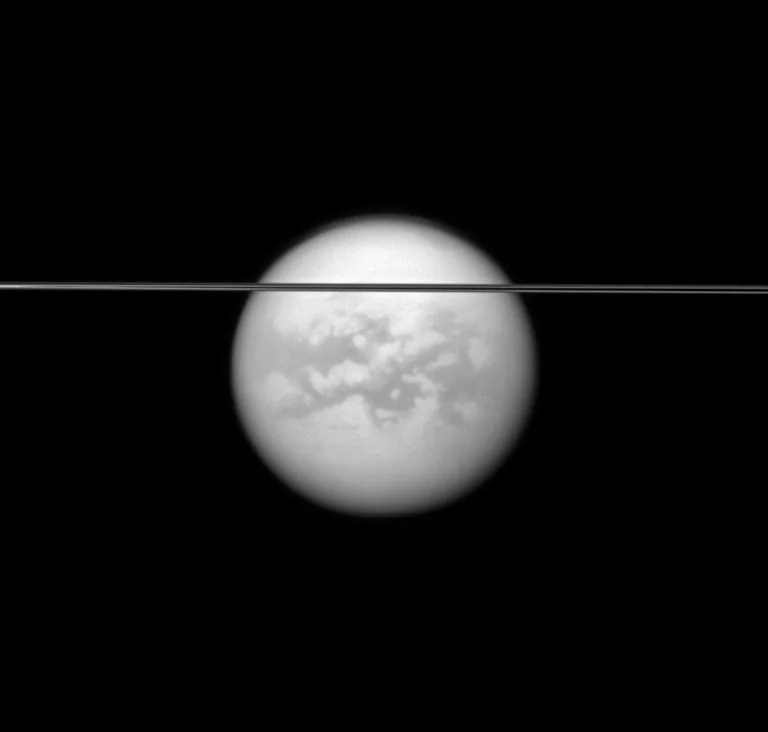 Saturn's rings cut across this view of the planet's largest moon, Titan.This view looks toward the southern, unilluminated side of the rings from just below the ringplane and toward the Saturn-facing side of Titan. The image was taken May 12, 2011.