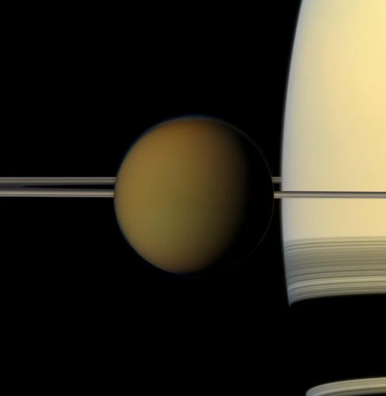 The colorful globe of Saturn's largest moon, Titan, passes in front of the planet and its rings in this true color snapshot from NASA's Cassini spacecraft. The combined images were obtained on May 21, 2011.
