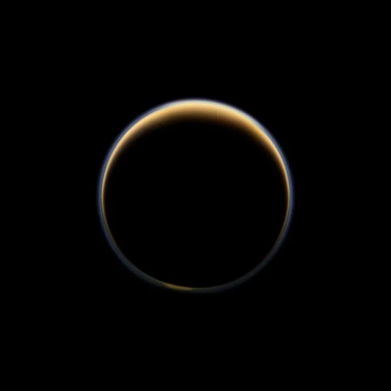 NASA's Cassini spacecraft looks toward the night side of Saturn's largest moon and sees sunlight scattering through the periphery of Titan's atmosphere and forming a ring of color. The images acquired to make this natural color view were taken on July 6, 2012