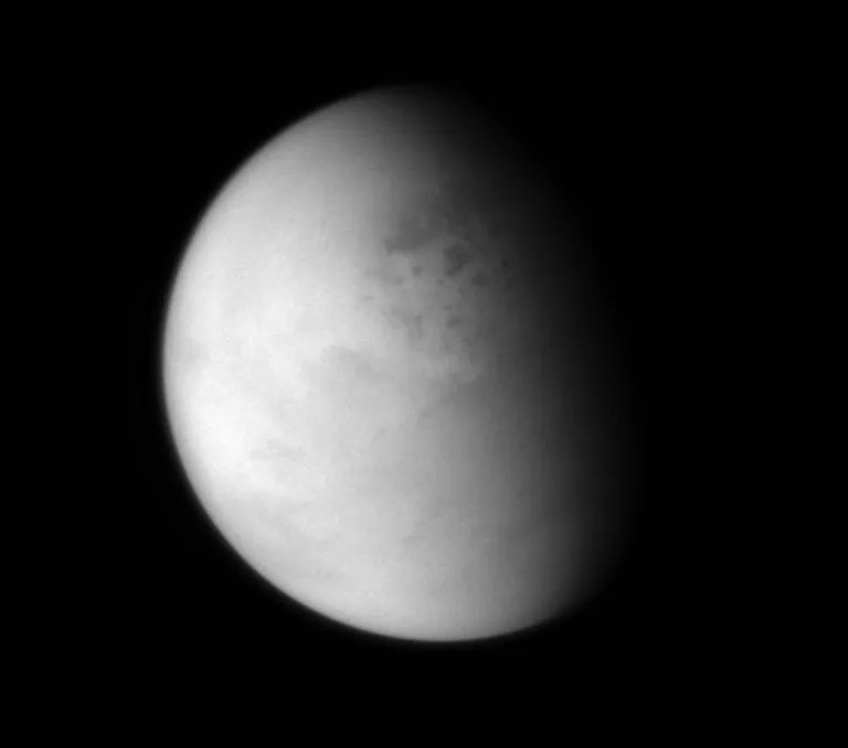 The Cassini spacecraft peers down through layers of haze to glimpse the lakes of Titan's northern regions. This image was released on April 7, 2014.