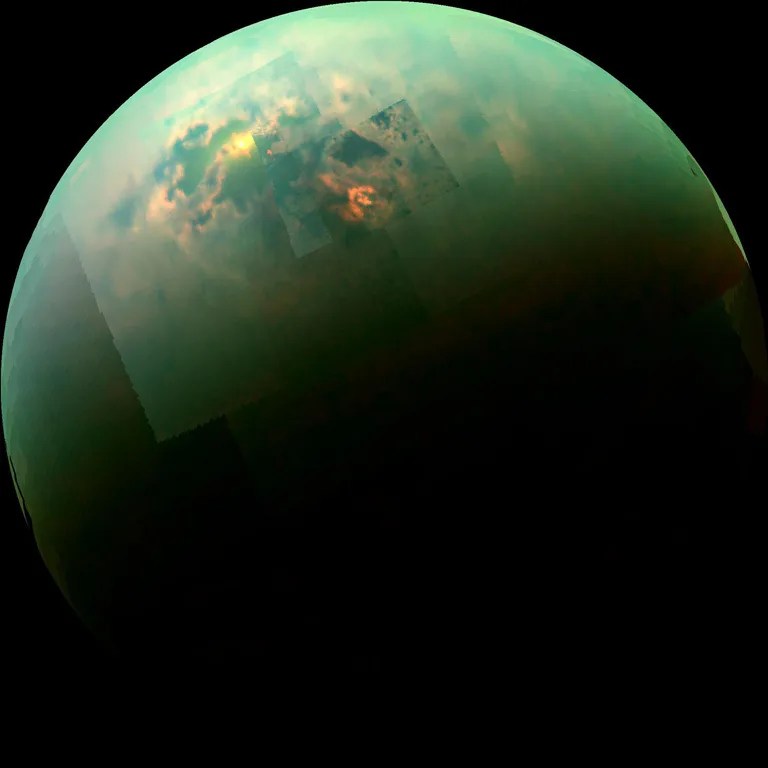 Global view of titan with sunlight glinting off seas and lakes.