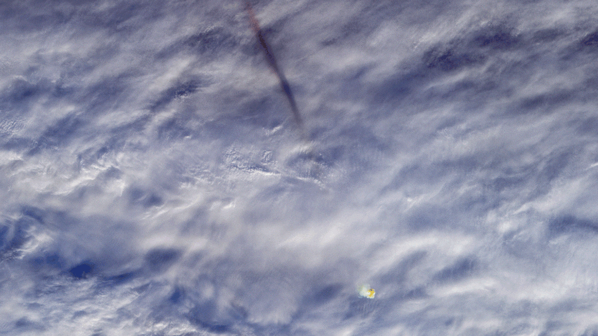 Streak of smoke from meteor above clouds.