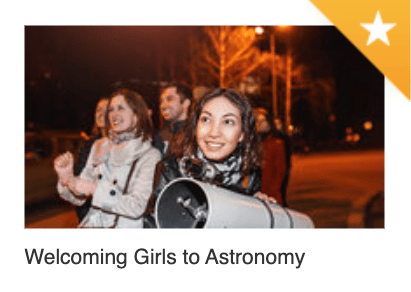 Photo of young woman smiling at a small telescope.