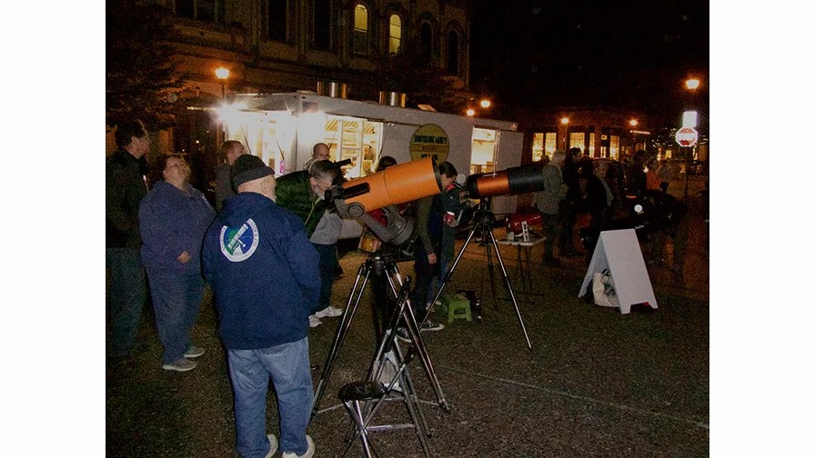 Nighttime photo of people using telescopes