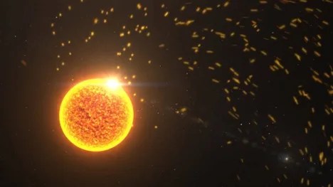 Artist concept of an orange sun against a black background with a bright eruption site and small flecks of orange representing particles and energy