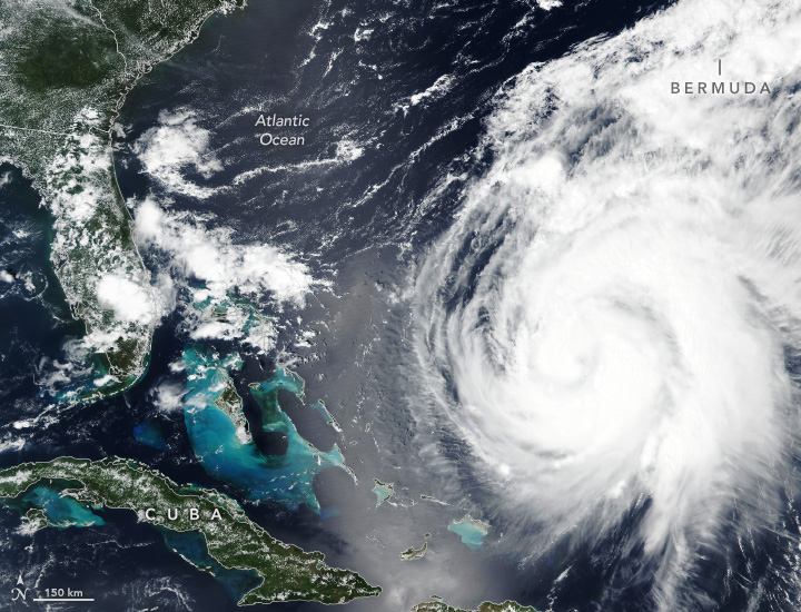 A swirl of clouds features on the right side of the image over the dark blue Atlantic Ocean. Cuba's long island borders the lower left of the image. Florida and the coast of the states of Georgia and South Carolina frame in the left side of the image.