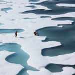 Science crew members retrieve a canister from melt ponds on the Arctic Ocean.