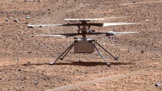 A small helicopter sits on the surface of Mars