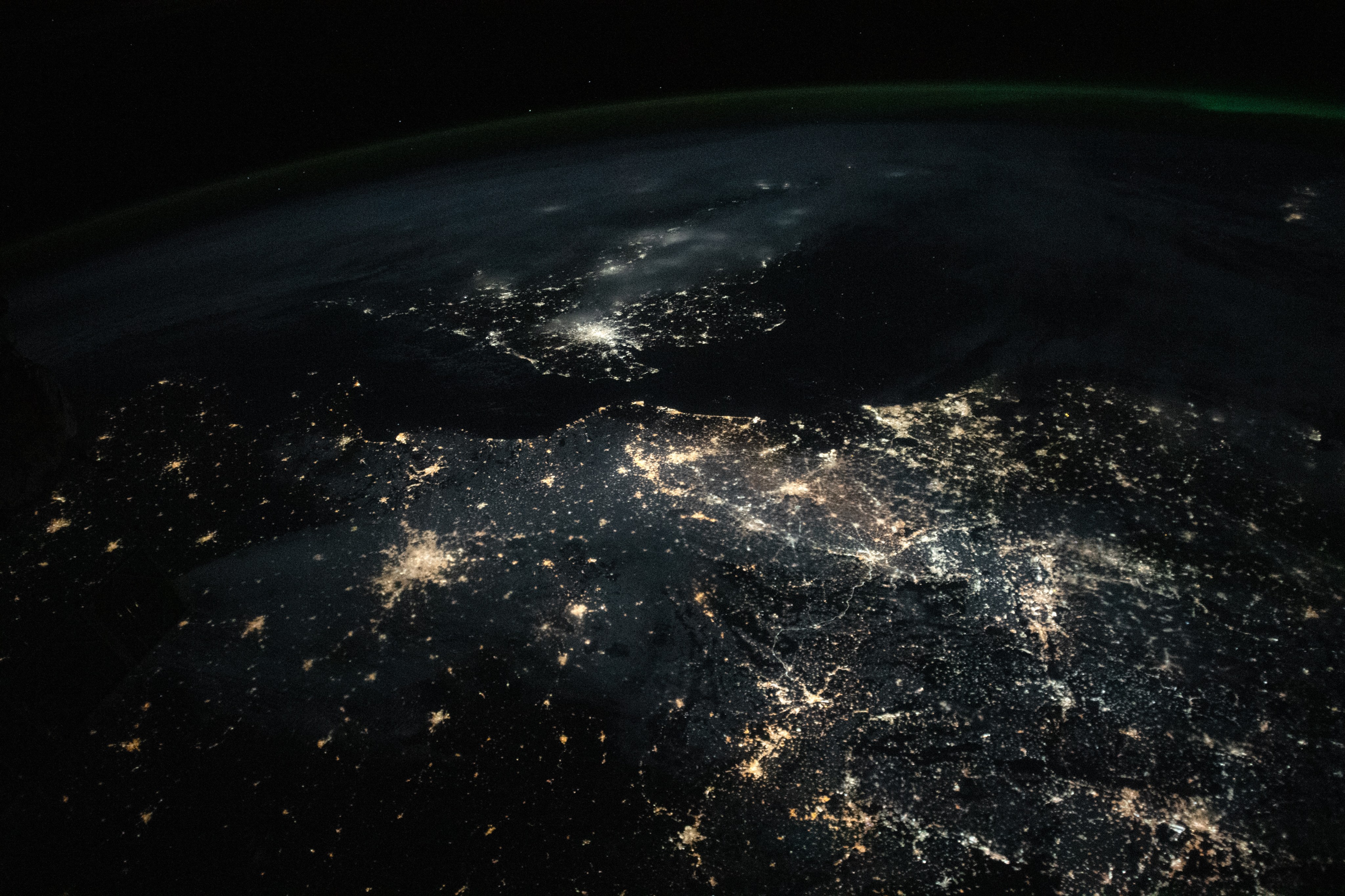 Light from cities and towns stands out against the darkness of the English Channel and the North Sea. Some of the largest cities in Western Europe are visible in the photo, including the capital cities of Paris, France; Amsterdam, Netherlands; and London, England. Lighted roads and infrastructure connect these bright metropolitan areas. The photo was taken at an oblique angle and includes Earth’s horizon—also known as Earth’s limb—near the top of the image.
