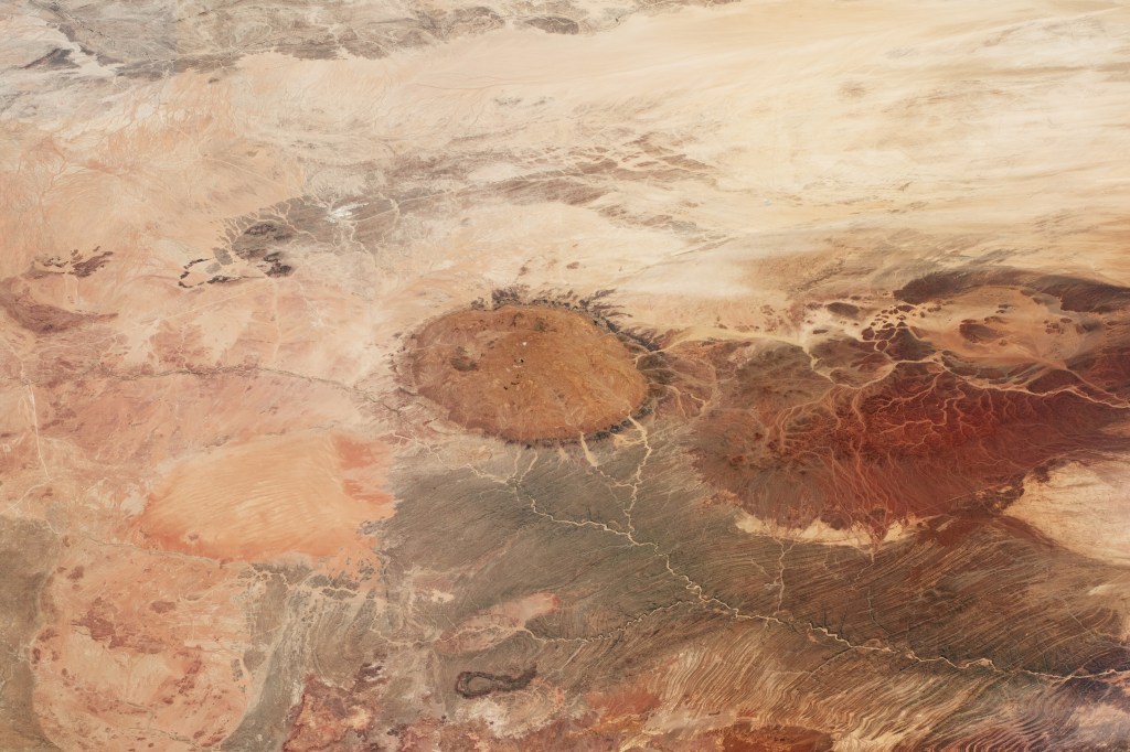 Image shows part of the central Namib Desert just inland from the Atlantic Ocean. Brandberg Massif, a circular mass of rock that forms Namibia’s highest mountain, is visible in the center of the image. The mountain stands 2,573 meters (8,442 feet) above sea level.