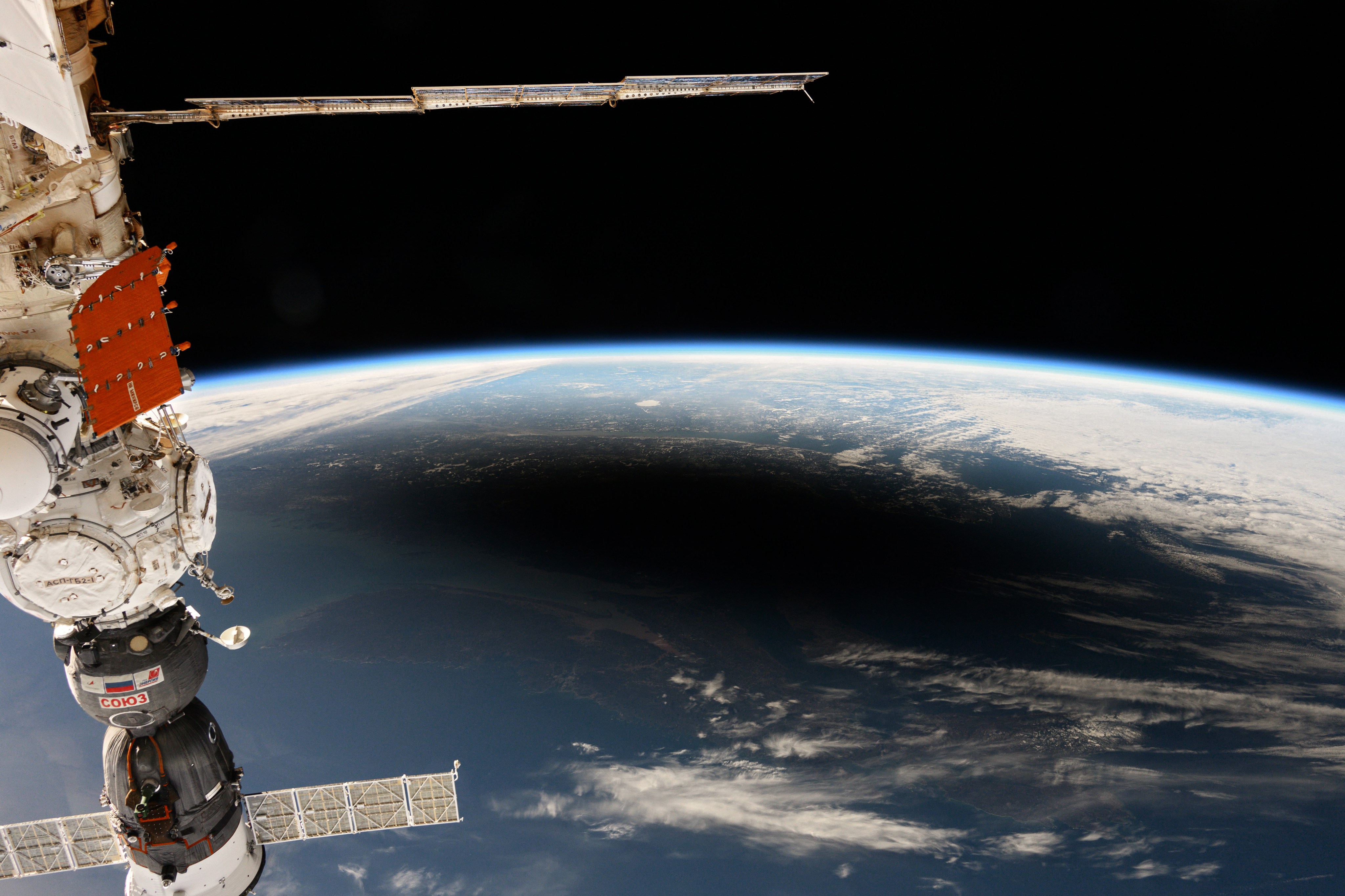 The image above, taken as the space station orbited above the North Atlantic, shows the eclipse’s dark shadow along with Earth’s bright horizon, or limb, at the boundary between the atmosphere and space. A crew ship docked to the space station is visible in the lower-left corner of the image.