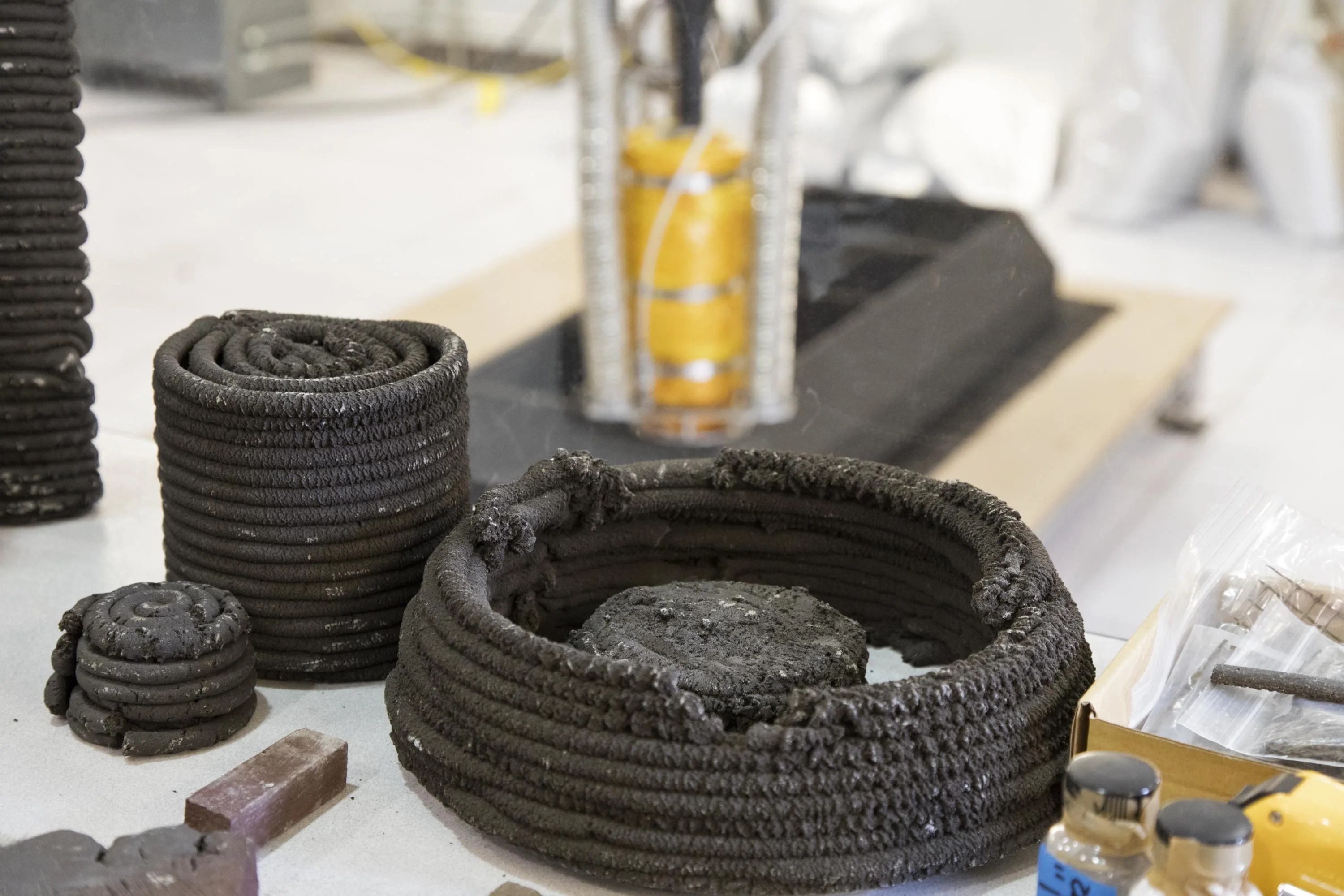 Coils of dark-colored material that were made by a 3-D printer out of simulated lunar dust.